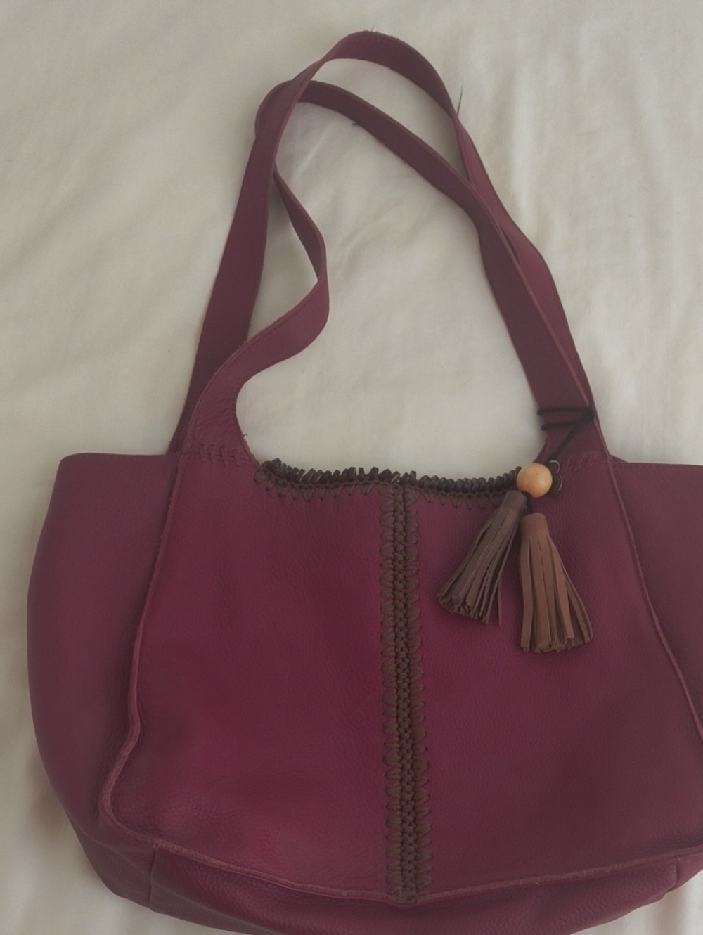 The Sak Red Leather Shoulder Bag with Tassel Accent.